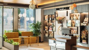 A modern interior with a reception desk, seating area, and shelves with various items. - INNSiDE by Meliá Tenerife Santa Cruz (Santa Cruz de Tenerife)