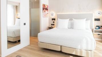 Ein modernes Hotelzimmer mit einem großen Bett, Nachttischen, einem Spiegel und einem Wandbild.
