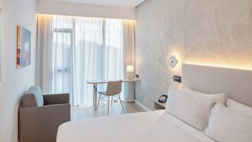 Une chambre d’hôtel moderne avec un grand lit, un bureau et une chaise.