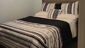 A bedroom with a bed, a ceiling fan, and a light fixture. - Cozy Treasure Home with private entrance (Buford)