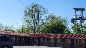 Un bâtiment avec un toit en tuiles et un parking.