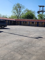 Un edificio con techo de tejas y estacionamiento.