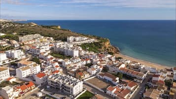 A coastal town with white buildings, a beach, and a clear view of the sea.