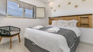 Een slaapkamer met een bed, een stoel, een raam en decoratieve wandelementen.