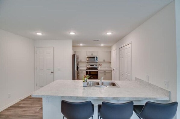 Enjoy cooking in this well-equipped kitchen with a central island, sink, and microwave.