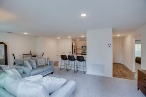 Relax in this stylish living space with a light blue sofa and modern kitchen area.