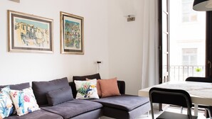 A modern living room with a sofa, a dining table, and two framed artworks on the wall. - Suite La Piazza by Wonderful Italy (Syracuse)