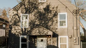A two-story house with a front porch, a garage, and a number '821' on the door.
