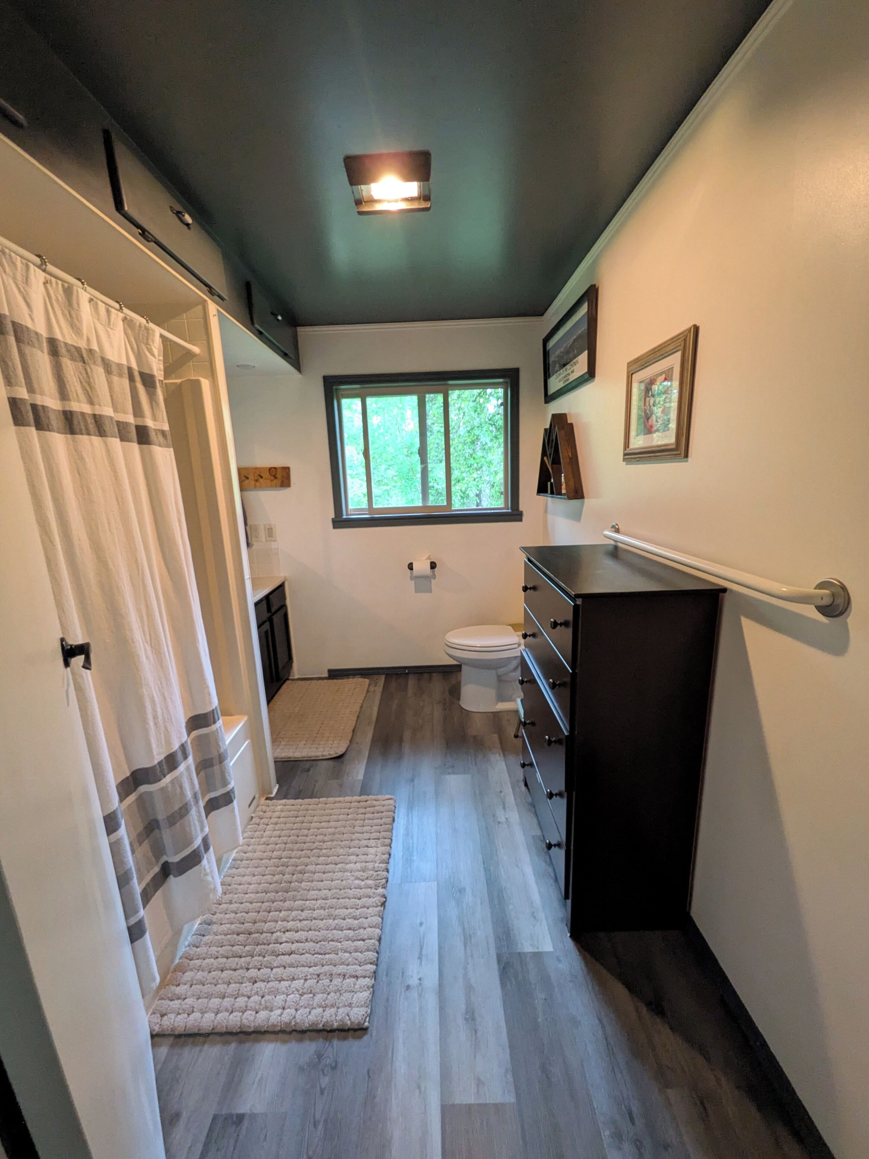 Une salle de bain avec une douche, des toilettes et une fenêtre.