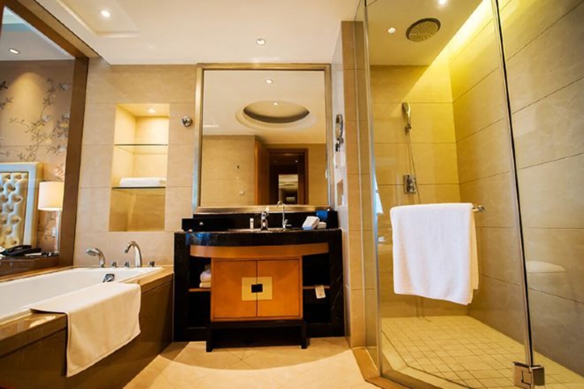 A modern bathroom with a bathtub, a sink with a mirror, and a shower area.