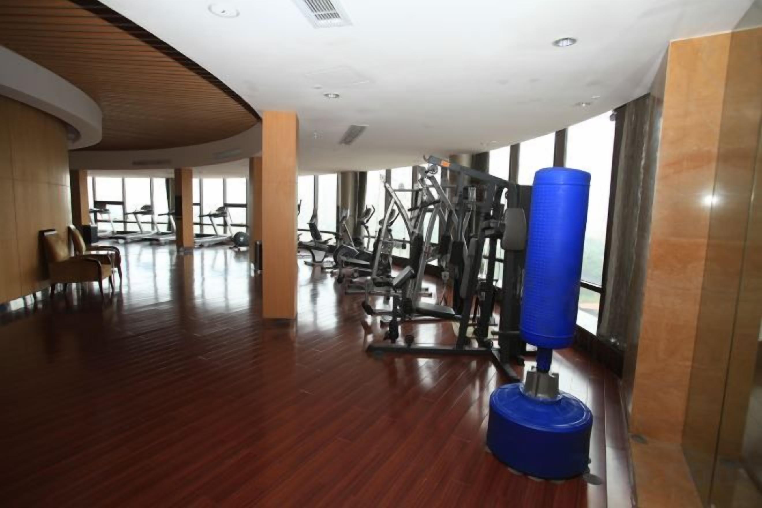 A spacious gym with exercise equipment and large windows.