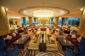 A spacious lobby with a central chandelier, multiple seating areas, and large windows. - Binjiang International Hotel (Tengzhou)