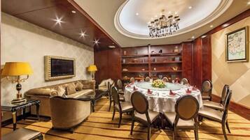 A formal dining room with a round table, chairs, and a chandelier.
