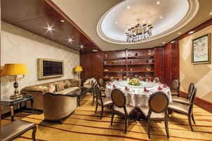 Un comedor formal con una mesa redonda, sillas y una araña.