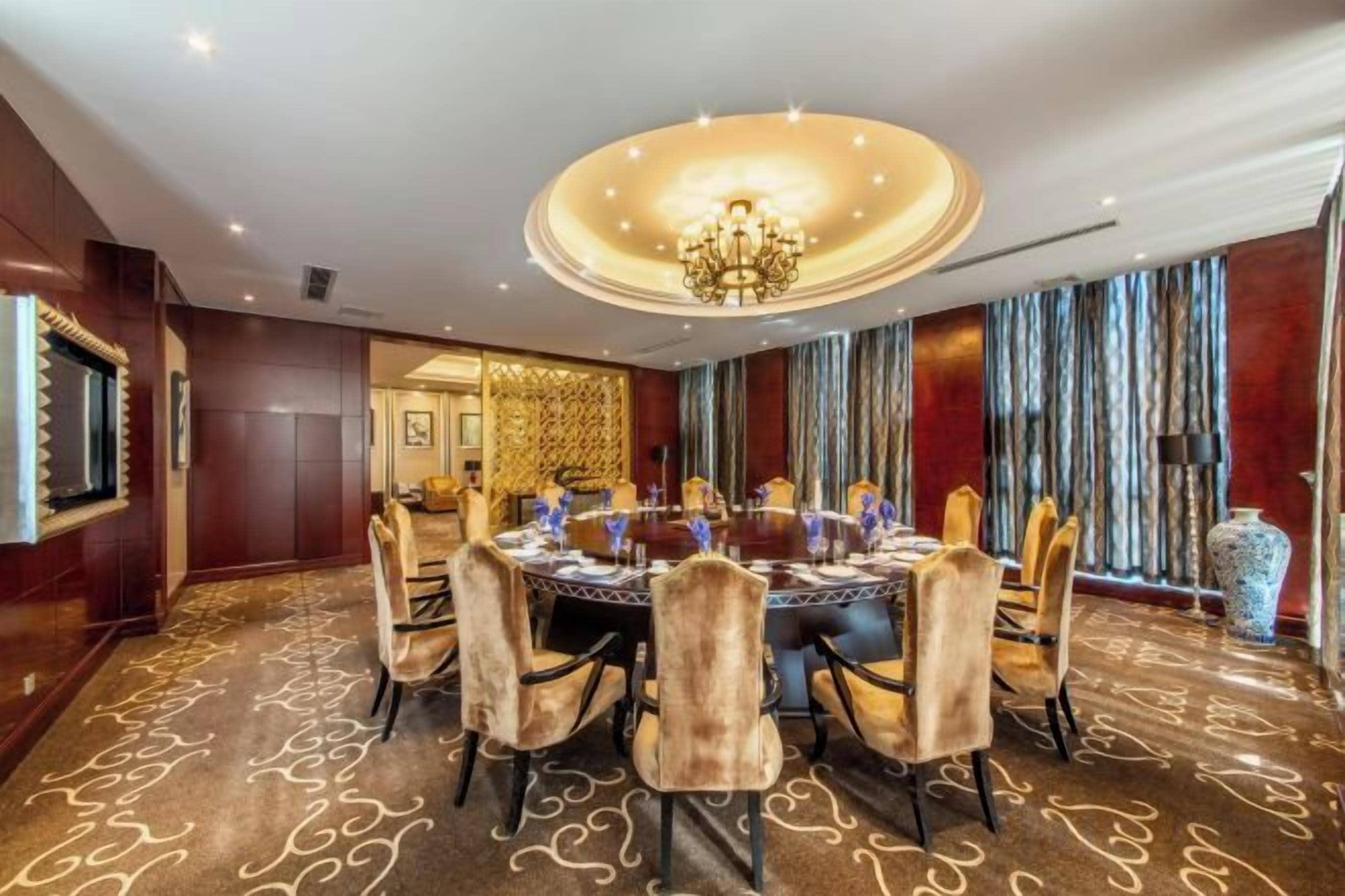 A conference room with a round table, chairs, and a chandelier.