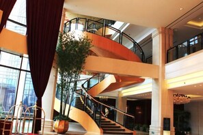 A multi-level interior with a spiral staircase, large windows, and indoor plants. - Binjiang International Hotel (Tengzhou)
