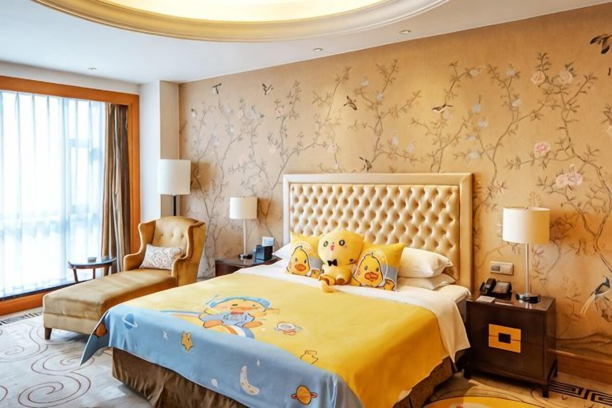 A hotel room with a large bed, two bedside tables, a chair, and a window with curtains.