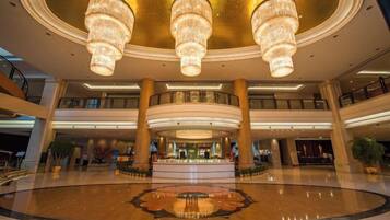 A spacious atrium with a central fountain, multiple levels, and large chandeliers.