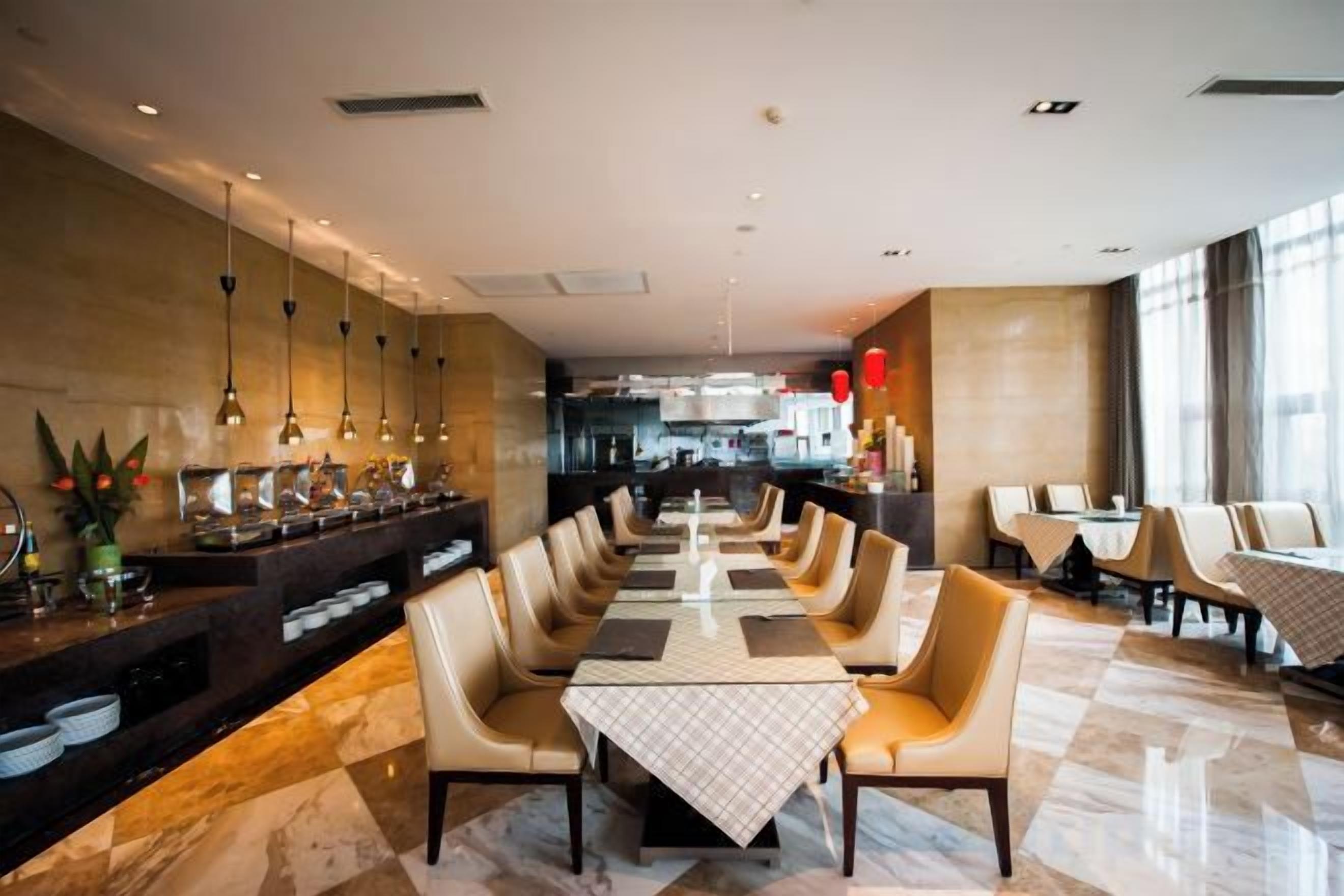 A restaurant with a long dining table, multiple chairs, and a bar area with a counter.