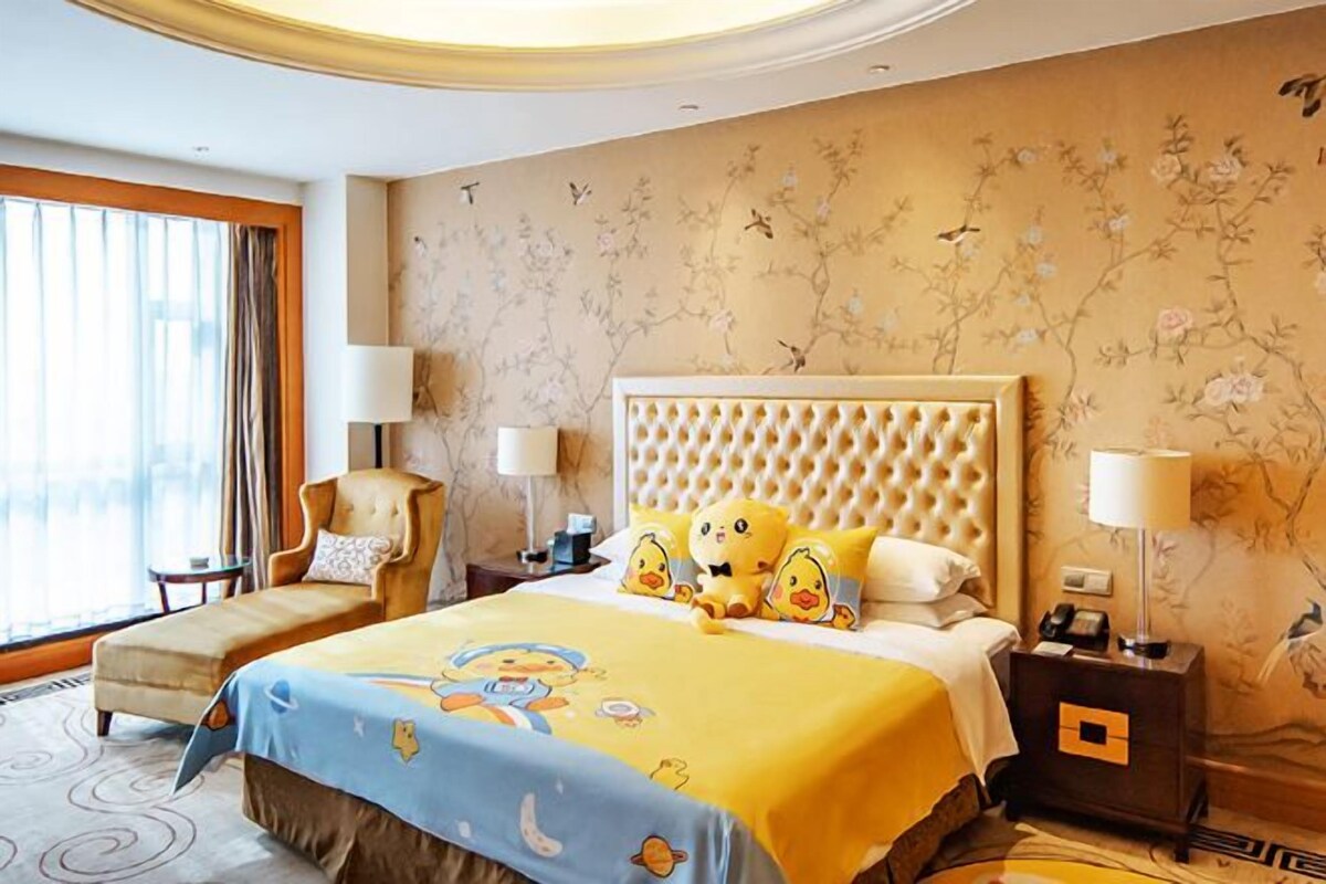 A hotel room with a large bed, two bedside tables, a chair, and a window with curtains.