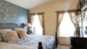 Une chambre à coucher avec un lit, des rideaux, une commode et un élément décoratif mural.