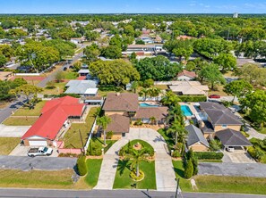 A residential area with houses, a swimming pool, and a well-maintained lawn. - Huge Luxury Heated Pool/Spa Villa w/ Game Room, Office, Exercise Area & More! (Tampa)