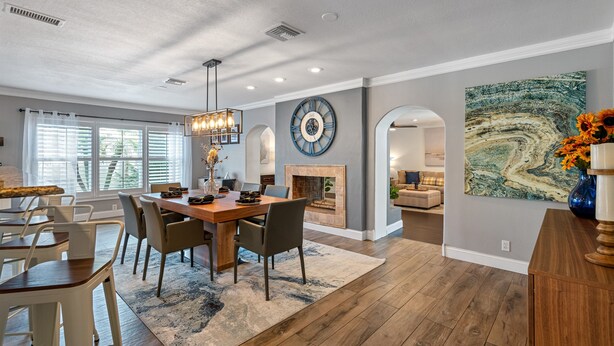 A spacious dining area with a wooden table and chairs, a fireplace, and a large clock on the wall. - Huge Luxury Heated Pool/Spa Villa w/ Game Room, Office, Exercise Area & More! (Tampa)