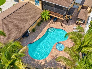 Una propiedad residencial con piscina, mobiliario de patio y una zona de estar cubierta al aire libre.