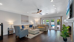 A spacious living room with a ceiling fan, two sofas, a coffee table, and a potted plant. - Huge Luxury Heated Pool/Spa Villa w/ Game Room, Office, Exercise Area & More! (Tampa)
