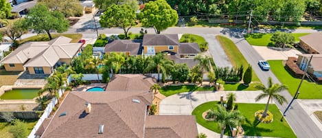 Un quartier résidentiel comprenant plusieurs maisons, une piscine et des pelouses bien entretenues.