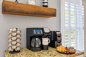 A coffee station with a coffee maker, a mug, and a pastry display. - Huge Luxury Heated Pool/Spa Villa w/ Game Room, Office, Exercise Area & More! (Tampa)