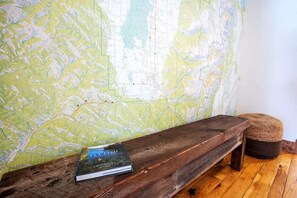 A wooden bench with a book titled "FLY FISH" against a wall with a map.