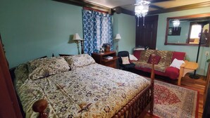 A bedroom with a large bed, a sofa, a mirror, and a chandelier. - Downtown 1 Bedroom Duplex can Sleep 5 Close to Everything (Indianapolis)