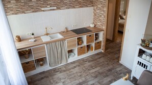 Una cocina moderna con salpicadero de piedra, encimera de madera y almacenamiento integrado.