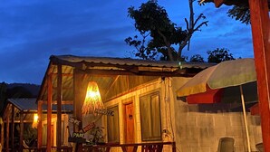 A rustic wooden house with a porch, a hanging light fixture, and a sign that reads "SOVRIE PARTE". - Las Rocas Village Ecohotel  (Acandi)