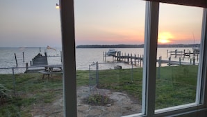 A view of a dock and a boat on a body of water during sunset.
