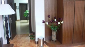 Ein Flur mit einer Lampe, einem Mülleimer und einer Blumenvase.