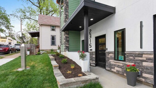 A modern two-story building with a stone facade, numbered 2315, featuring a well-maintained lawn and flower beds. - Cozy Studio in the Crossroads | 69 (Kansas City)