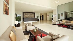 A spacious living area with sofas, a coffee table, and a kitchen in the background. - Ginger Gondia, Balaghat Road (Gondia)