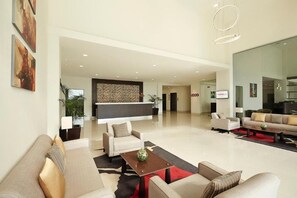 A spacious living area with sofas, a coffee table, and a kitchen in the background. - Ginger Gondia, Balaghat Road (Gondia)