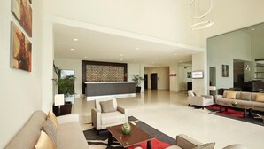 A spacious living area with sofas, a coffee table, and a kitchen area in the background. - Ginger Gondia, Balaghat Road (Gondia)