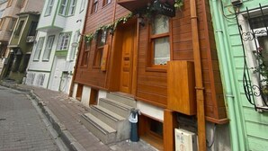 A two-story wooden building with a green awning and a sign that reads "Cherries". - New Cherry Hotel (Istanbul)
