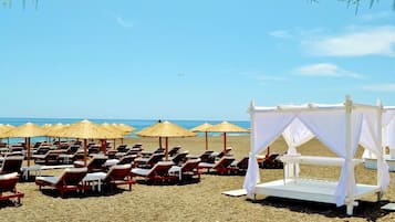 Am Strand, schwarzer Sandstrand, Strandtücher
