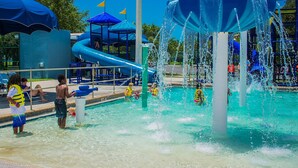 A water park with a pool, slides, and play structures.