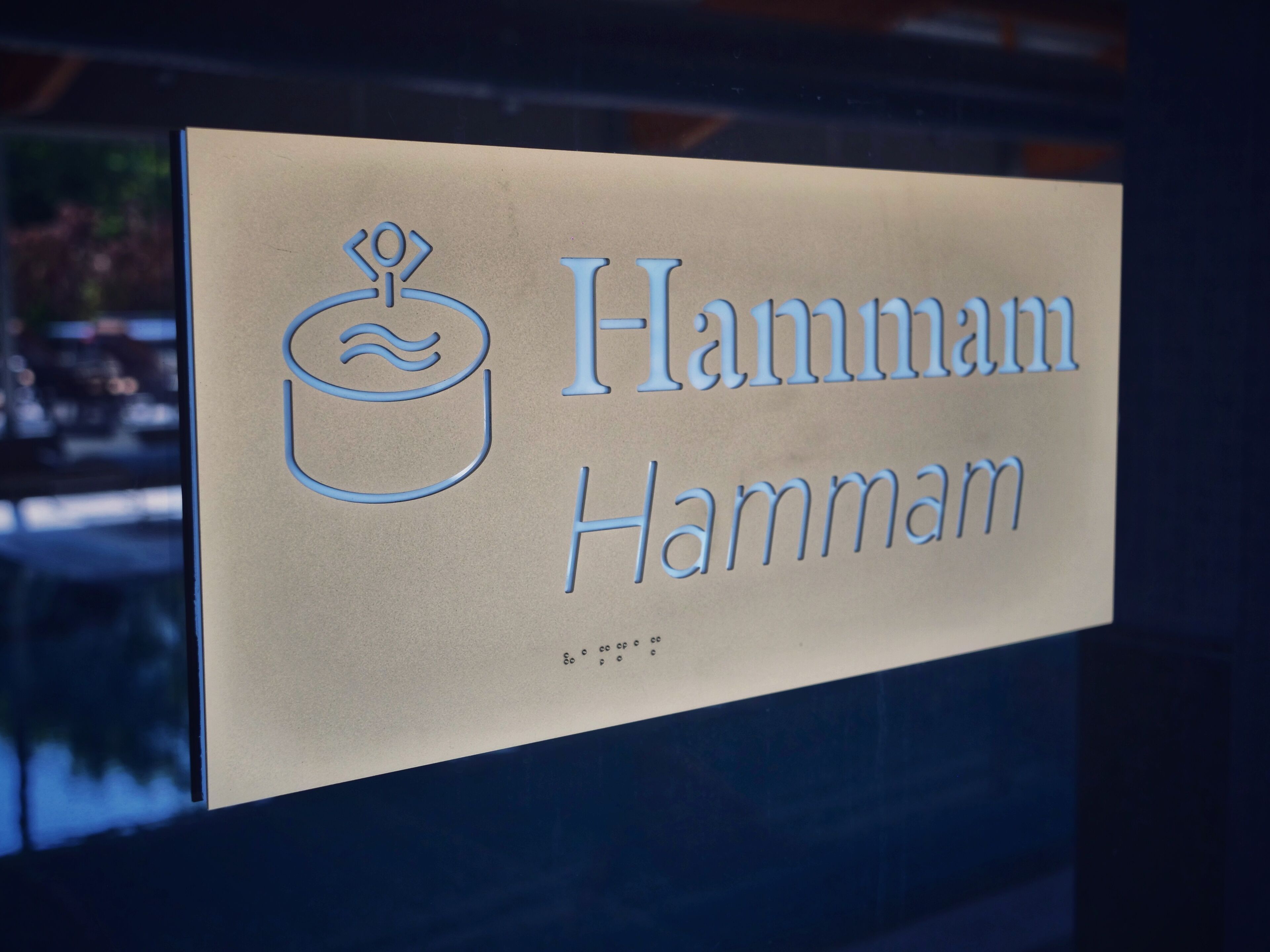 A sign with the name "Hammam Hammam" and a stylized bath icon.