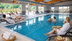 Une piscine intérieure avec des chaises longues et un panier rempli de serviettes.
