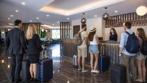 Un hall d’hôtel comprenant un comptoir d’accueil, un espace salon et une vue sur la salle à manger.