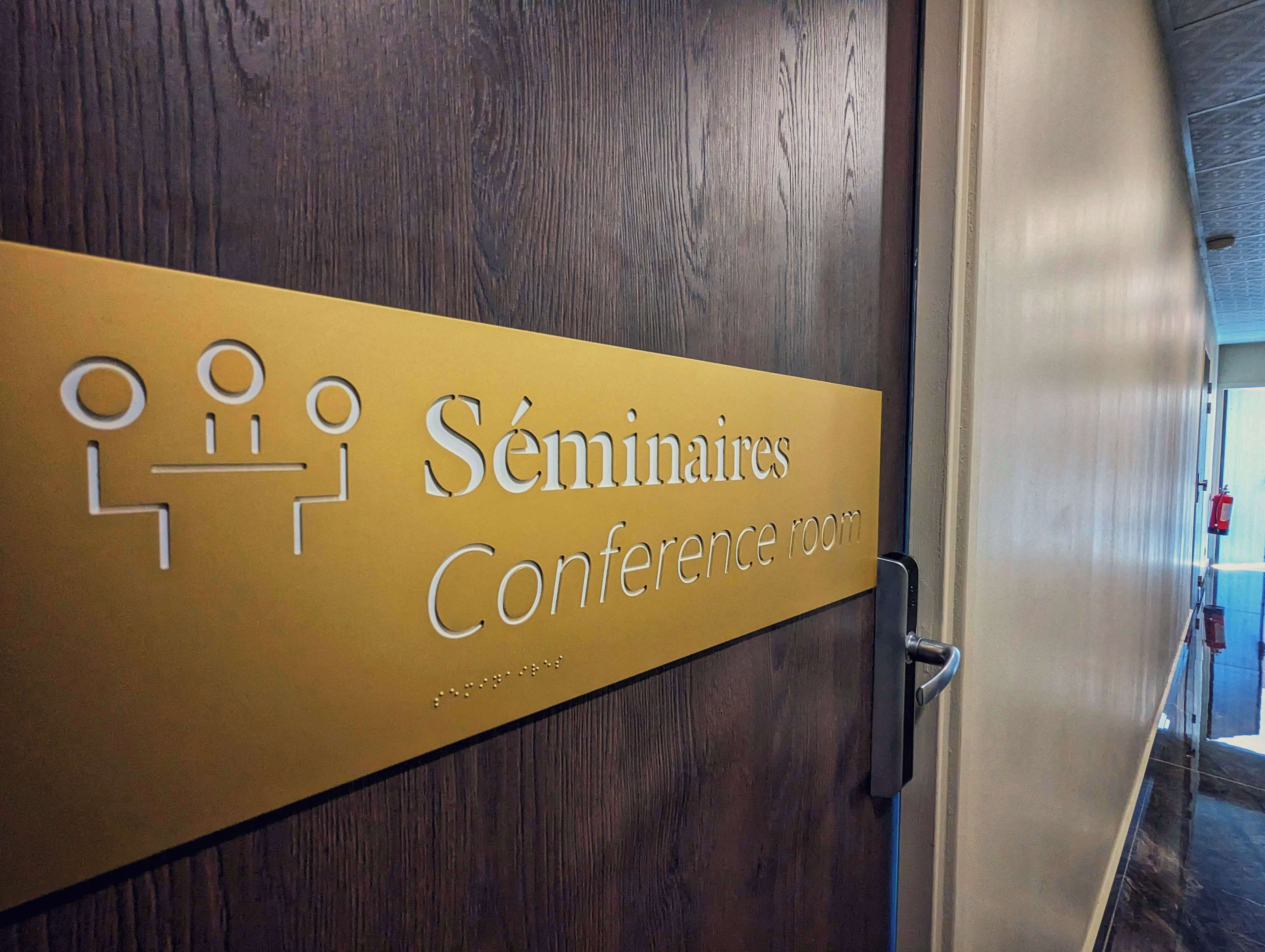 Porta de uma sala de conferências com uma placa indicando 'Séminaires Conference room'.