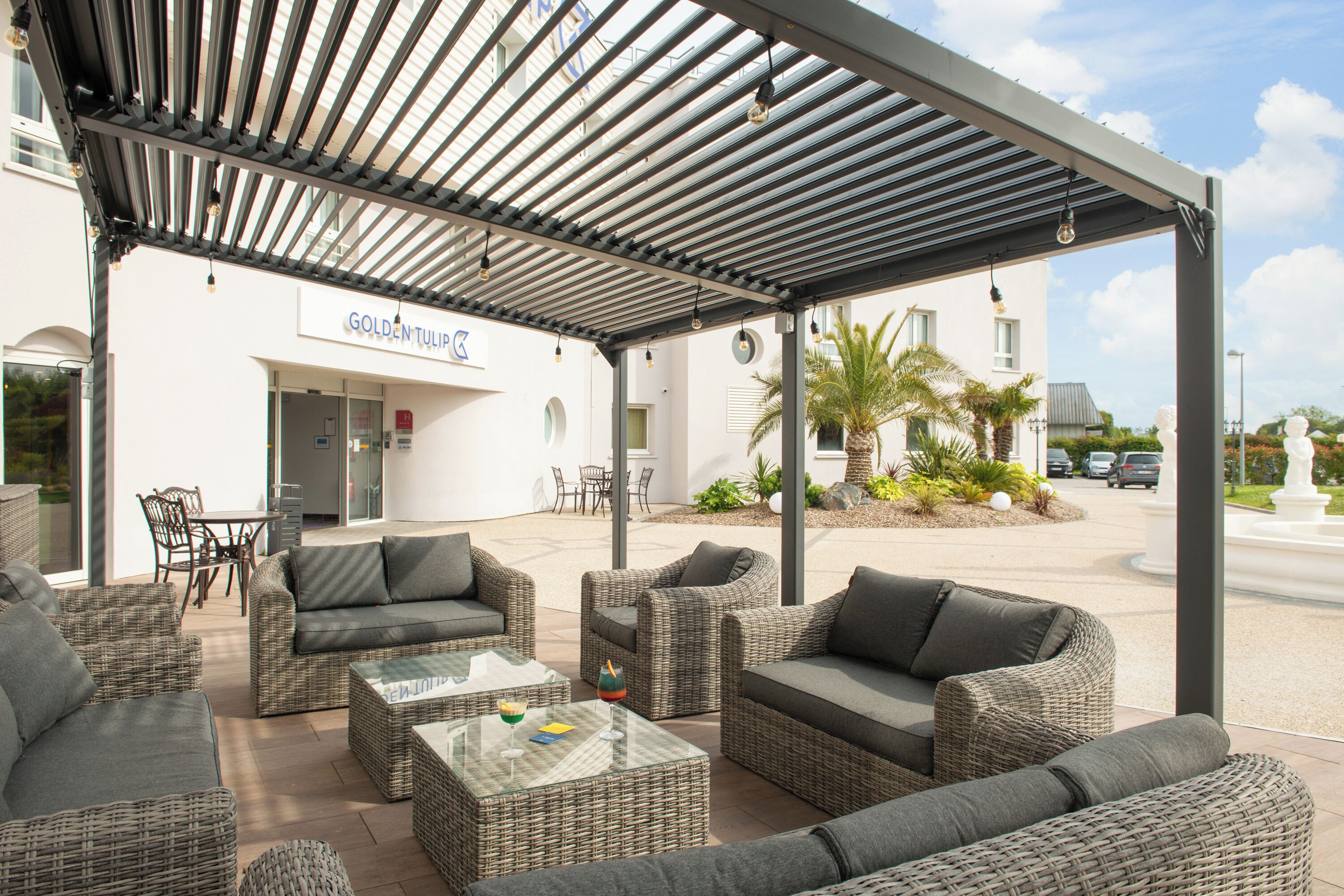 An outdoor seating area with wicker furniture and a covered patio.