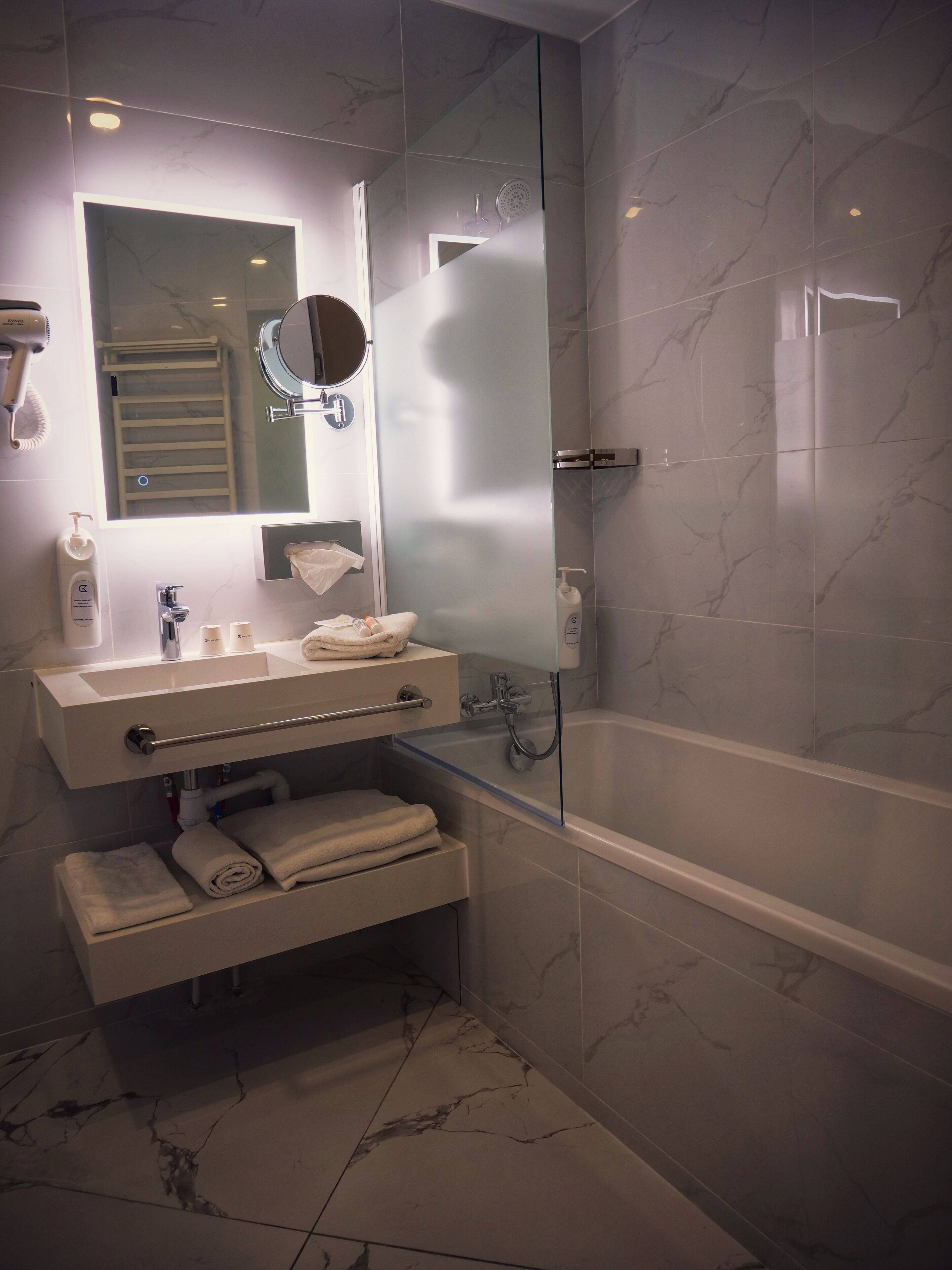 A modern bathroom with a glass-enclosed shower, a vanity with a mirror, and a bathtub.